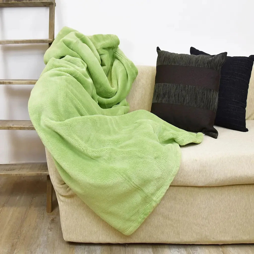 Plaid Prime Daunex in pile color pistacchio disteso sul divano